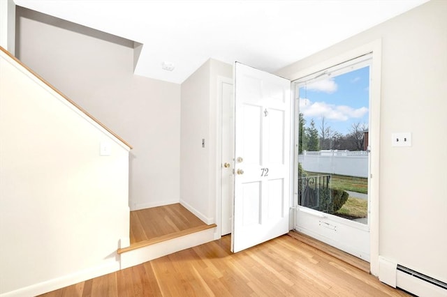 entrance foyer featuring plenty of natural light, light hardwood / wood-style floors, and a baseboard heating unit