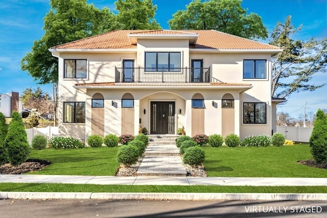 mediterranean / spanish-style house featuring a front yard and a balcony