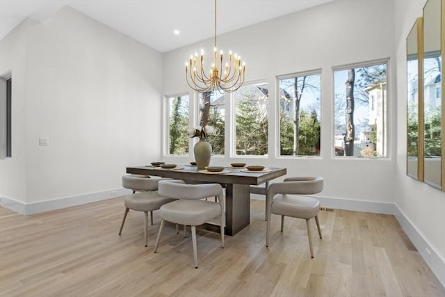 dining area with light hardwood / wood-style flooring and a notable chandelier