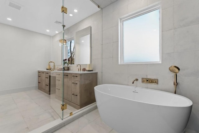 bathroom with vanity, separate shower and tub, and tile walls