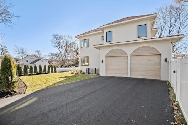 mediterranean / spanish house with a garage and a front yard