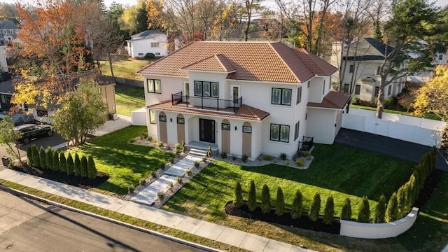 view of front of house with a front lawn and a balcony