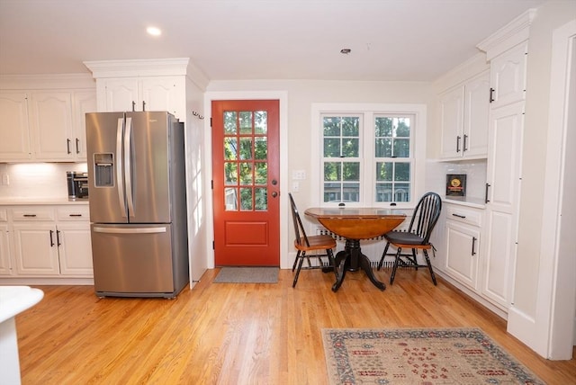 14 N Pleasant St, Dartmouth, MA 02748 - kitchen featuring stainless steel fridge, white cabinets, light wood-style floors, decorative backsplash, and light countertops