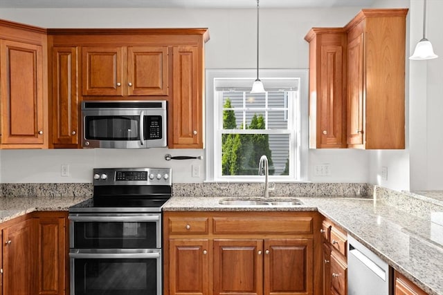 46 Walden Way Unit 46, Milford, MA 01757 - kitchen with stainless steel appliances, a sink, brown cabinets, hanging light fixtures, and light stone counters
