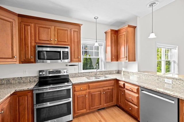 46 Walden Way Unit 46, Milford, MA 01757 - kitchen with stainless steel appliances, a sink, brown cabinetry, and light wood finished floors