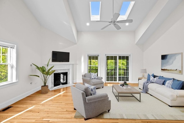 46 Walden Way Unit 46, Milford, MA 01757 - living area with high vaulted ceiling, a skylight, light wood-style floors, a premium fireplace, and baseboards