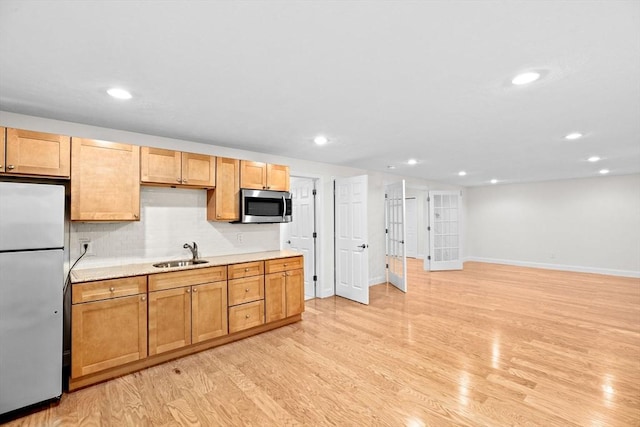 46 Walden Way Unit 46, Milford, MA 01757 - kitchen featuring appliances with stainless steel finishes, a sink, light countertops, baseboards, and light wood finished floors
