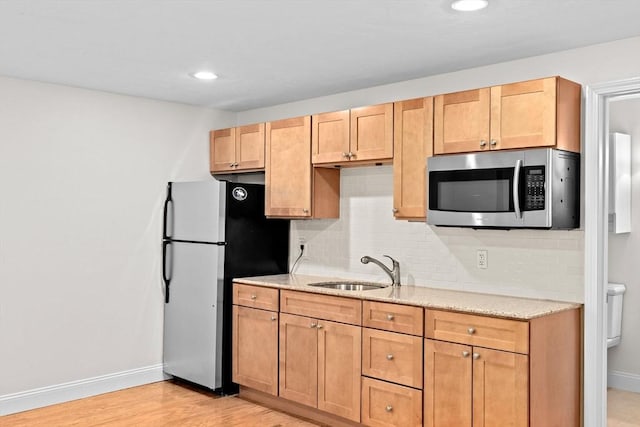 46 Walden Way Unit 46, Milford, MA 01757 - kitchen featuring stainless steel microwave, freestanding refrigerator, a sink, baseboards, and backsplash