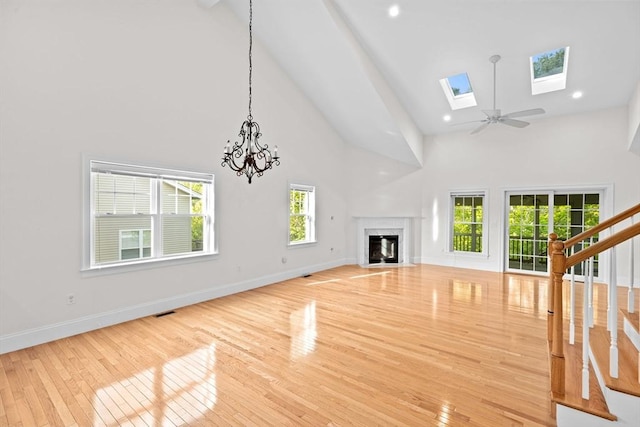 46 Walden Way Unit 46, Milford, MA 01757 - unfurnished living room featuring high vaulted ceiling, hardwood / wood-style floors, a fireplace, stairs, and baseboards