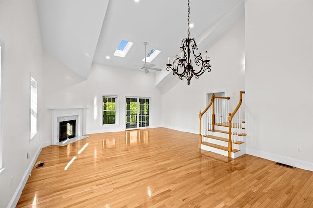 46 Walden Way Unit 46, Milford, MA 01757 - unfurnished living room with high vaulted ceiling, a skylight, stairs, a high end fireplace, and wood finished floors