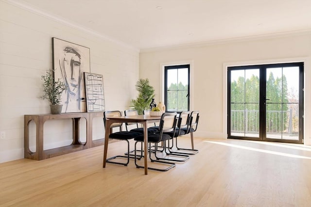 dining area featuring hardwood / wood-style floors, ornamental molding, and french doors