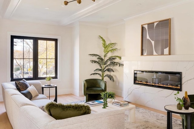 living room with beam ceiling, a premium fireplace, crown molding, and light hardwood / wood-style floors