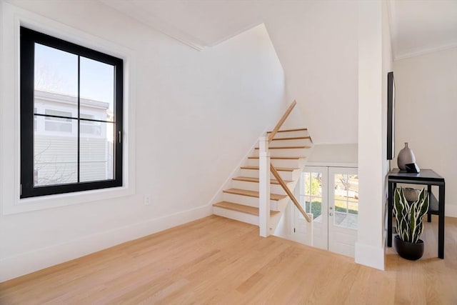 unfurnished room featuring french doors, ornamental molding, and hardwood / wood-style flooring