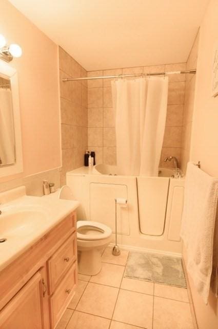 full bath with shower / tub combo with curtain, toilet, tile patterned flooring, and vanity