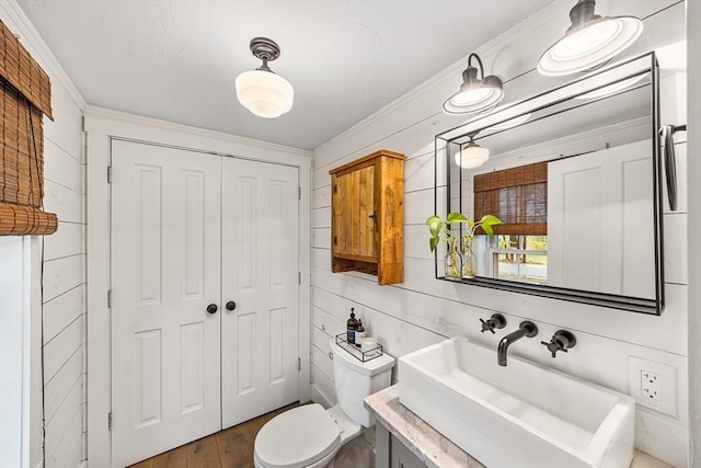 bathroom featuring crown molding, toilet, vanity, and wood finished floors