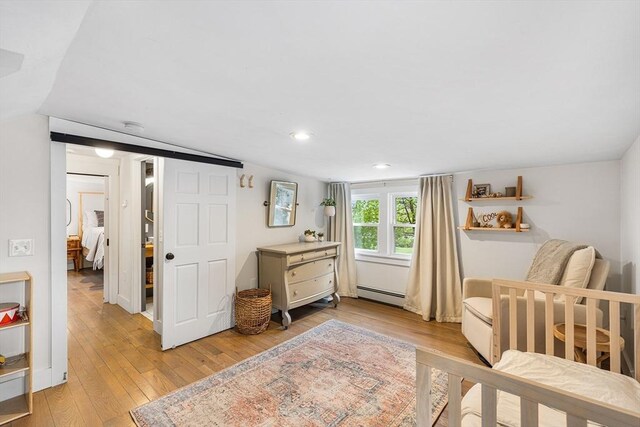 bedroom featuring baseboard heating, light wood-style floors, recessed lighting, and lofted ceiling