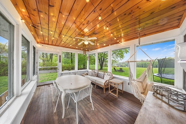sunroom / solarium featuring a ceiling fan, plenty of natural light, and an outdoor living space