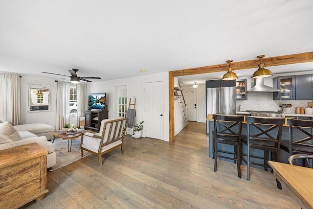 living room with hardwood / wood-style floors and a ceiling fan
