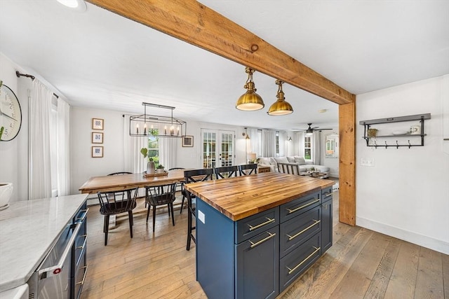 kitchen featuring french doors, wood counters, light wood-type flooring, plenty of natural light, and beamed ceiling