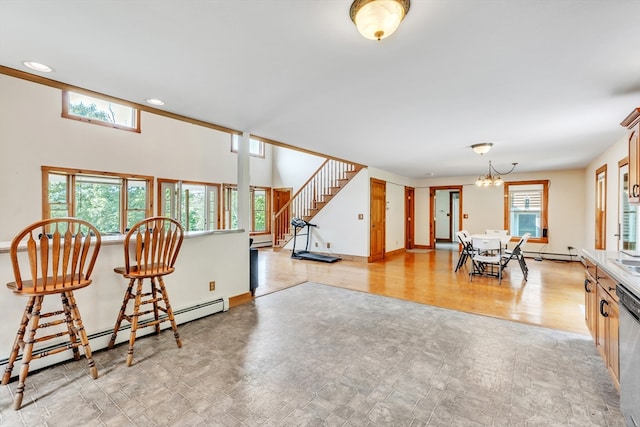 interior space with light hardwood / wood-style flooring, baseboard heating, pendant lighting, a chandelier, and dishwasher