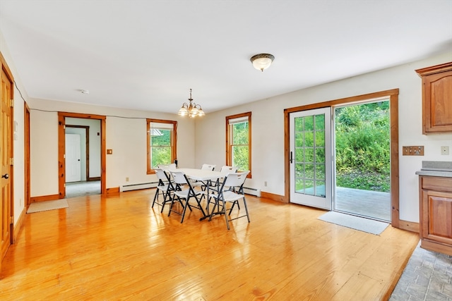 dining room featuring light hardwood / wood-style flooring, baseboard heating, and a chandelier