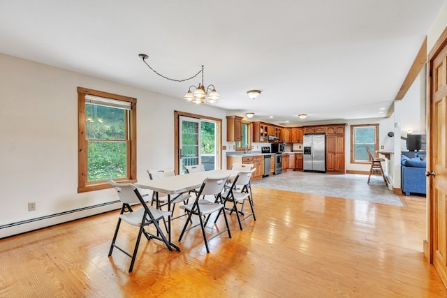 dining space featuring a notable chandelier, light hardwood / wood-style floors, and a baseboard radiator