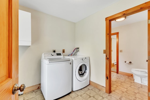 clothes washing area featuring washer and clothes dryer and light tile patterned floors