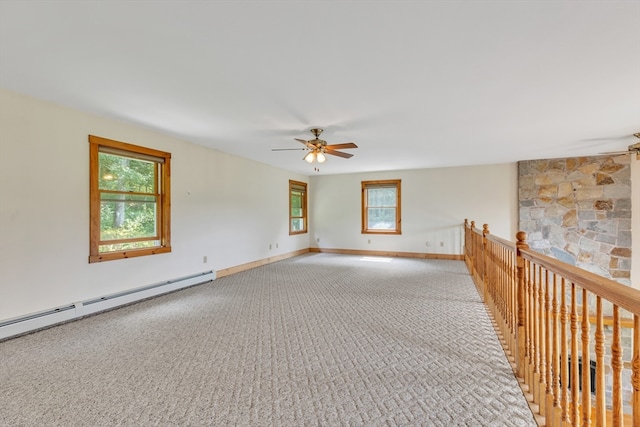 empty room featuring ceiling fan, carpet floors, and a baseboard heating unit