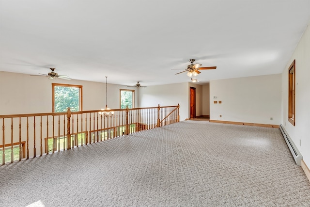 carpeted empty room with baseboard heating and ceiling fan with notable chandelier