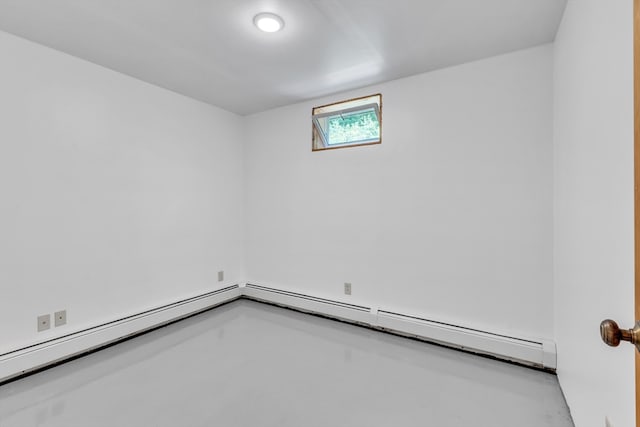 spare room with a baseboard heating unit and concrete flooring