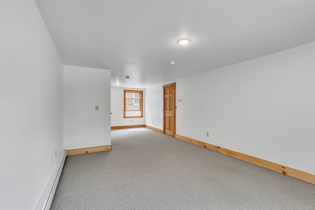 carpeted empty room with a baseboard heating unit