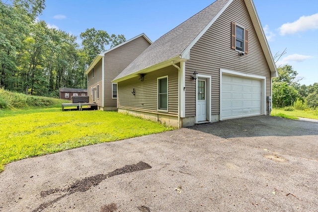 view of side of property with a lawn and a garage