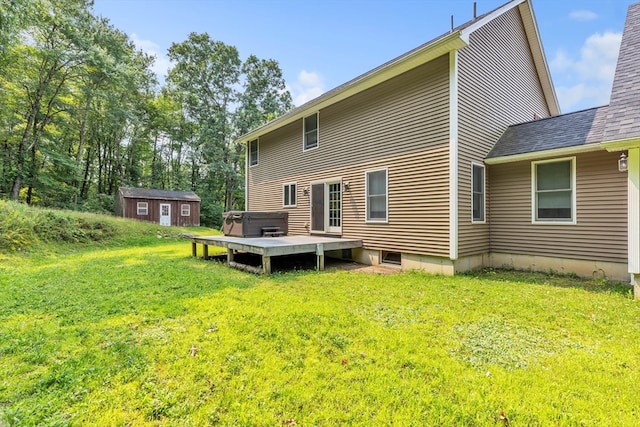 rear view of property featuring a deck, a shed, and a yard