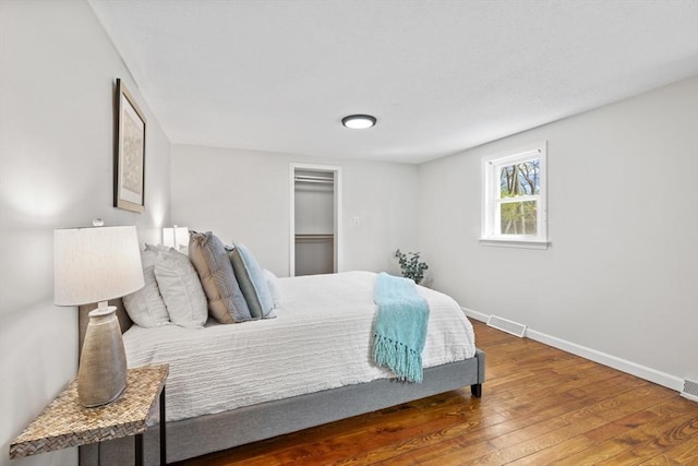 bedroom with visible vents, baseboards, and hardwood / wood-style floors