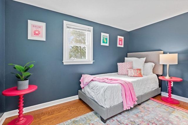 bedroom with wood finished floors and baseboards