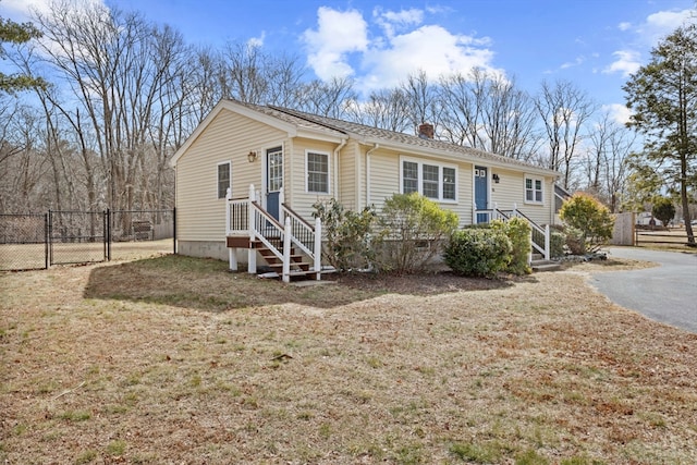 view of front of house with a front lawn, a gate, fence, and a chimney