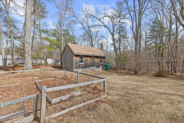 view of yard featuring a storage unit, an outdoor structure, and fence