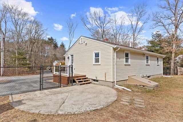 view of side of home featuring fence and a gate