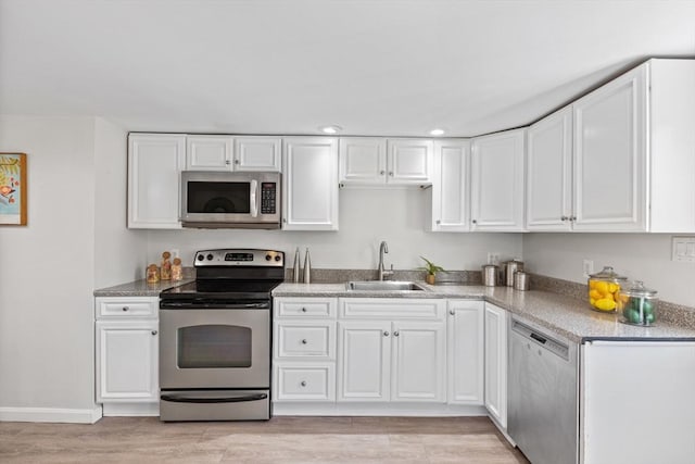 kitchen featuring a sink, white cabinets, light wood-style floors, and stainless steel appliances