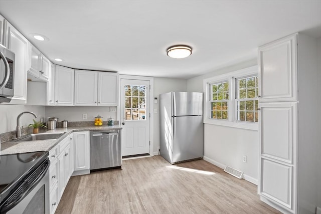 kitchen with visible vents, plenty of natural light, stainless steel appliances, and a sink