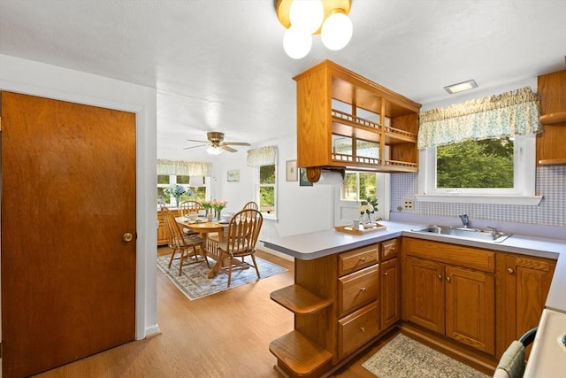 385 Norton Ave, Taunton, MA 02780 - kitchen with open shelves, light wood-style floors, a peninsula, brown cabinets, and light countertops