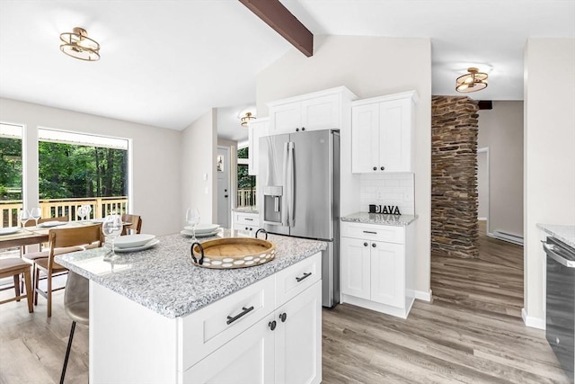 444 Loomis St, Westfield, MA 01085 - kitchen with stainless steel appliances, light wood-type flooring, backsplash, and a kitchen breakfast bar