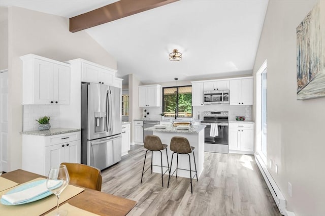 444 Loomis St, Westfield, MA 01085 - kitchen with appliances with stainless steel finishes, decorative backsplash, a baseboard radiator, and light wood-style flooring