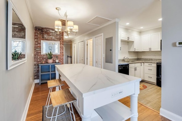 kitchen with pendant lighting, dishwasher, white cabinets, light wood-type flooring, and light stone counters