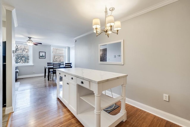 kitchen featuring light stone countertops, hanging light fixtures, crown molding, white cabinets, and ceiling fan with notable chandelier