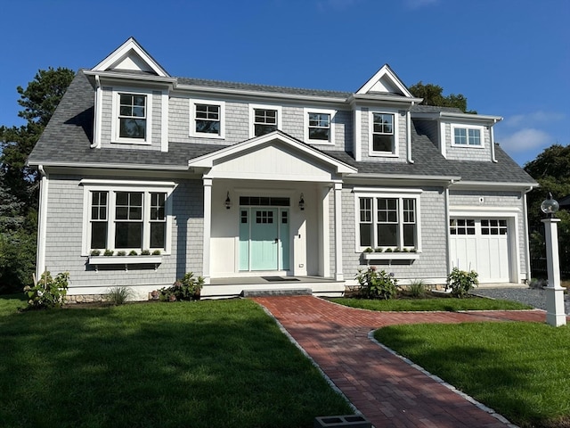 view of front of home with a garage, a porch, and a front lawn