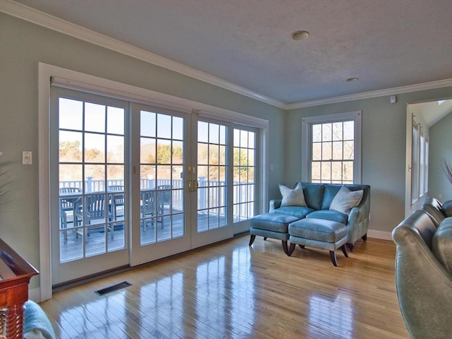 entryway with light hardwood / wood-style floors and crown molding