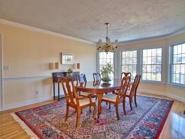 dining area with hardwood / wood-style flooring, an inviting chandelier, and crown molding