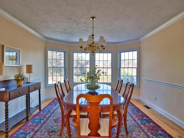 dining area featuring a chandelier, light wood-type flooring, and ornamental molding