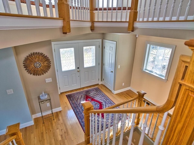 foyer entrance with light hardwood / wood-style floors and a high ceiling